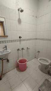a bathroom with a bucket and a toilet and a sink at Hotel Priyanka - 750 metres from nakki lake Near Bus Stand in Mount Ābu +6 photos