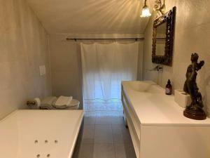 a bathroom with a tub and a toilet and a sink at Apartment AMARCORD Loft by Interhome in Biasca