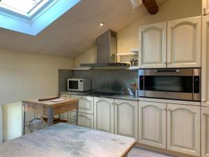 a kitchen with white cabinets and a microwave at Apartment AMARCORD Loft by Interhome in Biasca