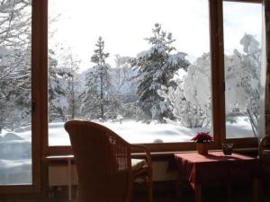 a table and chairs in front of a window with snow at Apartment Studio by Interhome in Bever