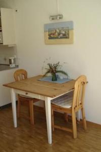 a wooden table with two chairs and a vase on it at Apartment Studio by Interhome in Bever +5 photos