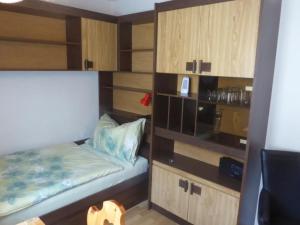 a small bedroom with a bed and wooden cabinets at Apartment Chesa Margretta by Interhome in Sils Maria