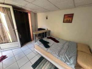 a small bedroom with a bed and a table at Petit studio cosy in Cersay