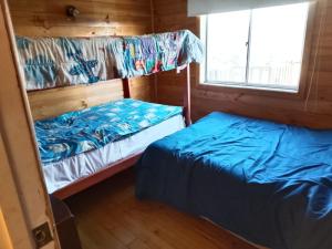 a bedroom with two bunk beds and a window at Cabaña tree in Boca Pupuya