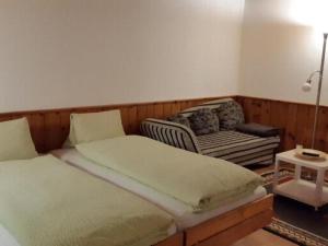 a bedroom with two twin beds and a chair at Apartment Studio Chesa Marias by Interhome in Sils Maria
