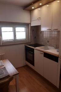a small kitchen with white cabinets and a sink at Apartment Studio Chesa Marias by Interhome in Sils Maria