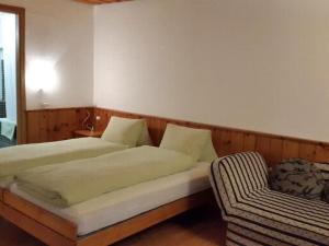 a bedroom with two beds and a chair at Apartment Studio Chesa Marias by Interhome in Sils Maria