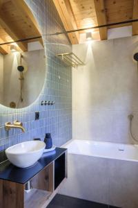 a bathroom with a white sink and a tub at Apartment Blue Alpine Lodge by Interhome in Rueras