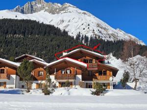 a ski lodge in front of a snow covered mountain at Apartment Blue Alpine Lodge by Interhome in Rueras