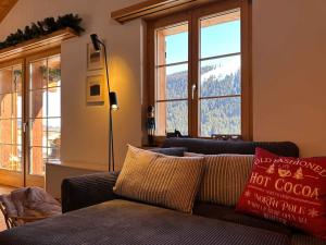 a living room with a couch and large windows at Apartment Blue Alpine Lodge by Interhome in Rueras