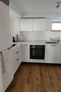 a kitchen with white cabinets and a black dishwasher at Apartment Günter by Interhome in Sagogn