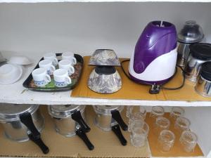 a shelf with cups and a purple and white blender at Casa Iris - One Bedroom in a 3BHK Apartment in Hyderabad