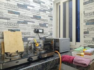 a kitchen with a counter with a microwave and a wall at Casa Iris - One Bedroom in a 3BHK Apartment in Hyderabad