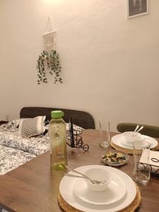 a wooden table with plates and a bottle on it at Casa Iris - One Bedroom in a 3BHK Apartment in Hyderabad +5 photos