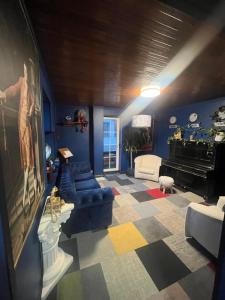 a living room with a couch and a piano at Broken bed hootel in Kaunas