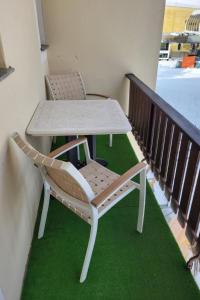 a table and chairs on a balcony with green grass at Apartment Chasura by Interhome in Pontresina