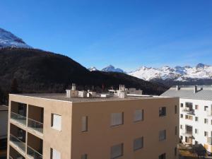 a view of a building with mountains in the background at Apartment Chasura by Interhome in Pontresina