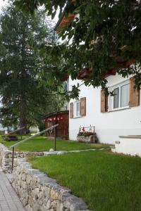 a house with a retaining wall and a yard at Apartment 3 Bettwohnung by Interhome in Sils Maria