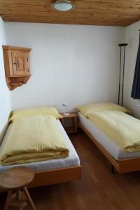 a bedroom with two beds and a table and a lamp at Apartment 3 Bettwohnung by Interhome in Sils Maria