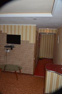 ヘルソンにあるJohn Howard apartment 2 roomの壁にテレビとテーブルが備わる客室です。