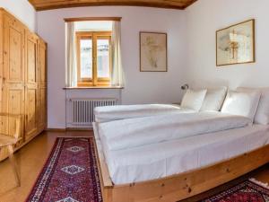 a large white bed in a room with a window at Apartment Chesa Müller by Interhome in Zuoz