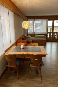 a dining room with a table and chairs and a couch at Apartment Wohnung Curtins by Interhome in Pontresina +12 photos