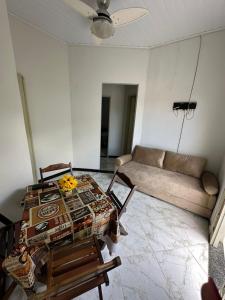 a living room with a table and a couch at Casa aconchegante em Barra dos Coqueiros in Barra dos Coqueiros +6 photos