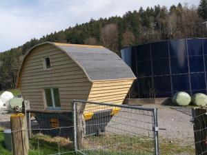 a smallshed sitting in a field next to a fence at Holiday Home Tiny Hause by Interhome in St. Gallen +8 photos
