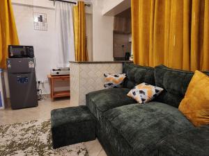 a living room with a green couch and yellow curtains at Ansan Comfort in Gatunga +32 photos