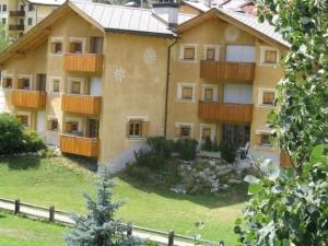 an apartment building with a yard and a fence at Apartment Culaischem 2 by Interhome in Zuoz