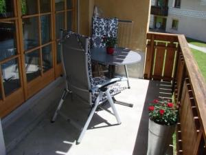 a chair sitting on a porch with a table at Apartment Culaischem 2 by Interhome in Zuoz +10 photos