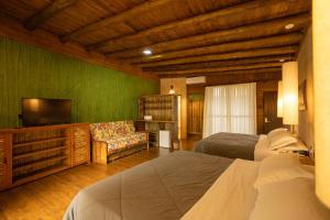 a bedroom with two beds and a flat screen tv at Grajagan Surf Resort in Ilha do Mel