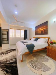 a large bedroom with two beds and a large painting at Njiwa suites 1034 in Mombasa