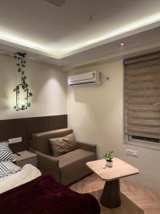 a room with a bed and a chair and a table at Luna Stays in Greater Noida