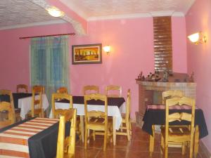 jadalnia z różowymi ścianami, stołem i krzesłami w obiekcie Rem Hotel w mieście Fianarantsoa