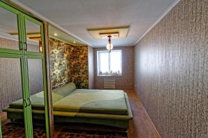 a bedroom with a green bed and a window at 2 room Apartment above Verona Cafe Very Center in Kherson