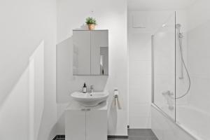 a white bathroom with a sink and a shower at U1 Metro Nearby - 1-BR - fast Wi-Fi in Vienna