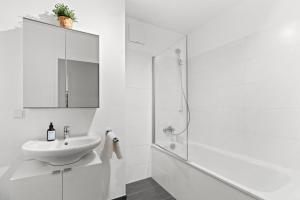 a white bathroom with a sink and a shower at U1 Metro Nearby - 1-BR - fast Wi-Fi in Vienna