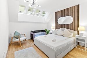 a white bedroom with a bed and a chair at U1 Metro Nearby - 1-BR - fast Wi-Fi in Vienna