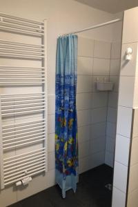 a shower in a bathroom with a blue shower curtain at Apartment Heidestrauch by Interhome in Thülsfeld