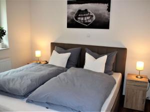 two beds in a bedroom with two lamps on tables at Apartment Heidestrauch by Interhome in Thülsfeld