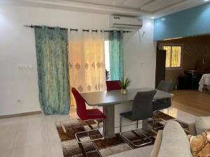 a living room with a table and red chairs at Villa Aida in Djilore