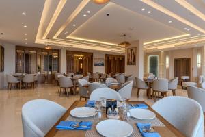 a restaurant with tables and chairs in a room at Golden Pillar Hotel in Aqaba