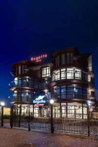 a building with a sign on it at night at Regatta Hotel in Ulyanovsk