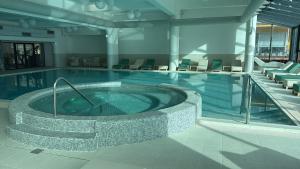 a large pool with a hot tub in a building at SINAI Experience in Sinaia