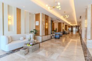 a lobby with a couch and chairs in a building at Golden Pillar Hotel in Aqaba