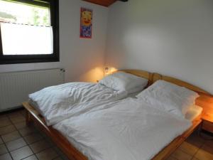 an unmade bed in a room with a window at Holiday Home by Interhome in Großwürden