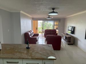 a living room with two chairs and a table at 34 Laguna La Crete in Uvongo Beach