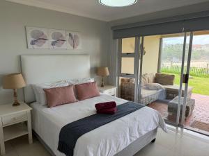 a bedroom with a bed and a living room at 34 Laguna La Crete in Uvongo Beach
