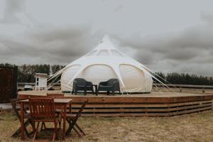 a tent with chairs and a table on a deck at Kay Bell in Masterton